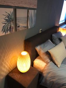 a bedroom with a bed and a table with a lamp at Dunes & Sea at Kijkduin in The Hague