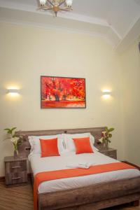 una camera da letto con un grande letto con cuscini arancioni di TURACO INTERCOUNTY RESORT a Maragoli