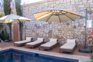 a patio with chairs and an umbrella next to a pool at Gamma Morelia Vista Bella in Morelia