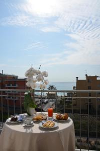 a table with plates of food on a balcony at Hotel Villa Paolina in Pietra Ligure
