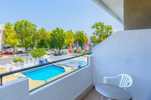 een balkon met uitzicht op een zwembad bij Simple Hotel Hersonissos Sun in Chersonissos