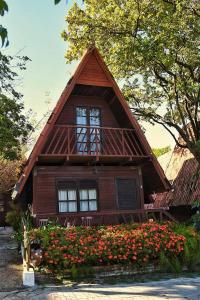 una pequeña casa de madera con flores delante en Chalet Suisse en Natal