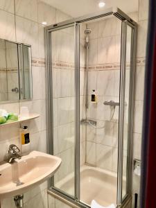 een badkamer met een douche en een wastafel bij Montana Hotel Köln-Bonn Airport in Troisdorf