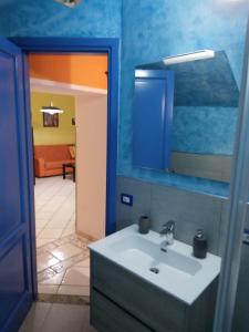een badkamer met een wastafel en een spiegel bij Appartamento Asia in Lipari