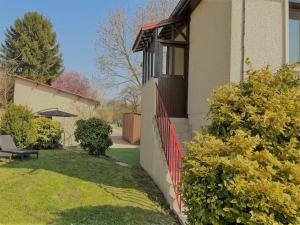 una casa con una recinzione rossa nel cortile di Gîte du Lapin Bleu a Coole