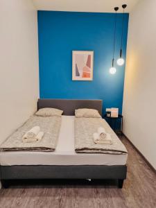 - une chambre dotée d'un lit avec un mur bleu dans l'établissement Taskovic Apartment, à Ljubljana