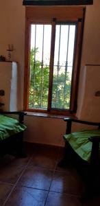 a room with two beds and a large window at Molino de Santos in Benarrabá