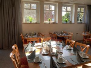 een eetkamer met tafels, stoelen en ramen bij Hotel Diamant in Wedel