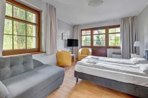a hotel room with a bed and a couch at Dom & House - Apartamenty Zacisze in Sopot