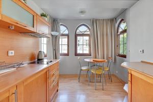 a kitchen with wooden cabinets and a table and chairs at Apartamenty Zacisze & by Noclegi Renters in Sopot