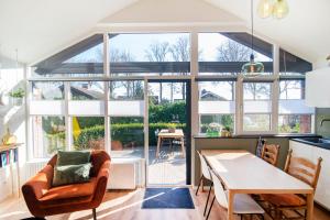 a kitchen and dining room with a large window at Loohuisje 32 in Aalten