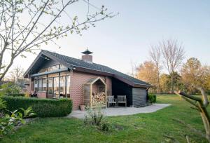 una casa de ladrillo con techo negro y ventanas en Loohuisje en Aalten