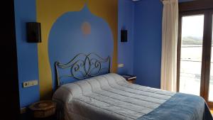 1 dormitorio con 1 cama con pared azul en Nuevo Hotel Sydney, en Suances