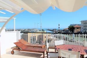 a balcony with two chairs and a table and a pier at Residence Fiorella in Cattolica