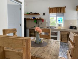 une cuisine avec une table et un vase avec des fleurs. dans l'établissement Villa Coconut, à La Verita