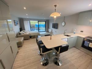 uma cozinha e sala de estar com uma mesa e um sofá em The North Cove, 20m to the Sea, Modern Studio Apartment em Portrush