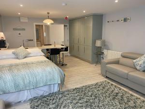 um quarto com uma cama, um sofá e uma secretária em The North Cove, 20m to the Sea, Modern Studio Apartment em Portrush