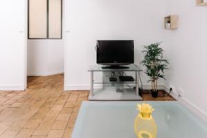 a living room with a television on a table at bnbgônes - LE SAINT VINCENT- HYPERCENTRE WIFI NETFLIX in Lyon