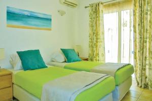 two green beds in a room with a window at Fig Tree in Fánai