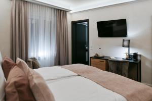 una camera d'albergo con letto e TV di Boutique Hotel Canel a Würzburg