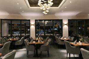 a restaurant with tables and chairs and a chandelier at Boutique Hotel Canel in Würzburg