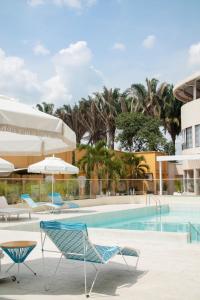 una piscina en un hotel con sillas y sombrillas en Hotel Campestre Nala, en Palmira
