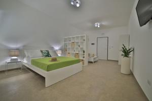 um quarto com uma cama grande e um cobertor verde em GIARO' APARTMENTS em Porto Cesareo