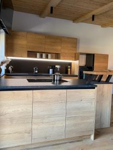 uma cozinha com armários de madeira e um balcão preto em Chalet Tuxer em Achenkirch