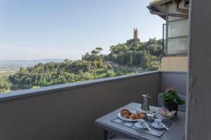 una mesa con un plato de repostería en el balcón en Casa Raffaello en San Miniato