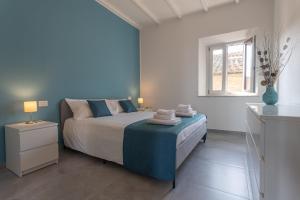 a bedroom with a bed with blue walls and a window at Casa Raffaello in San Miniato