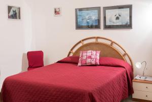 una camera con letto e piumone rosso di VILLA PATERTE a Marina di Mancaversa