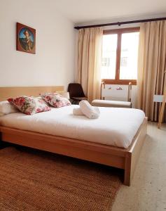 een slaapkamer met een groot bed met witte lakens en kussens bij Rambla - Palma center in Palma de Mallorca