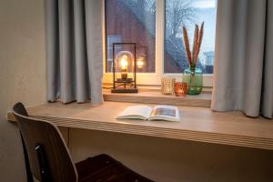 ein Fensterbrett mit zwei Büchern und einer Lampe darauf in der Unterkunft Verwalter Haus Apartment 2 in Bad Segeberg