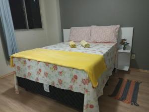 Braga Apartamento Temporada Maceió في ماسيو: سرير عليه نعلين اصفر
