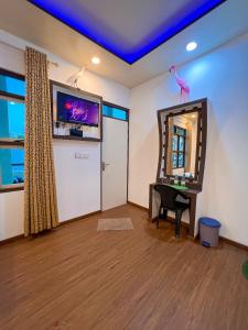 a room with a mirror and a table and a tv at Sunview Residence in Kaashidhoo