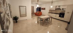 een keuken en een woonkamer met een tafel en stoelen bij Searenity in Marsaxlokk