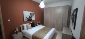 una camera con un letto bianco e una parete marrone di Searenity a Marsaxlokk