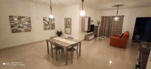 een woonkamer met een tafel en stoelen en een televisie bij Searenity in Marsaxlokk