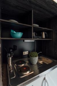 a kitchen sink with pots and pans on top of it at Hotel Bloemfontein in Borkum