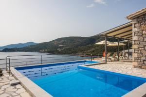 a swimming pool with a view of the water at Amousso Bay Villas in Marantochori