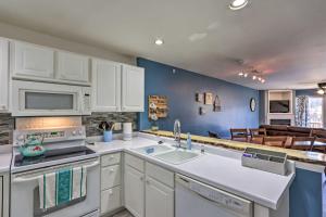 a kitchen with white cabinets and a blue wall at Step-Free Camdenton Condo with Boat Ramp, Dock, Slip in Camdenton