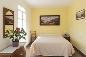 um quarto com uma cama branca e uma janela em A Pousa Pensión rural (Camino de Santiago Sanabrés) em Armariz