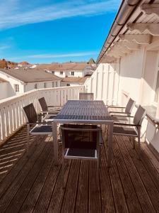 - une table de pique-nique sur une terrasse avec des chaises sur un balcon dans l'établissement Ferienwohnung Strandeck - Inklusive Strandkorb in den Sommermonaten, à Göhren 9 autres photos
