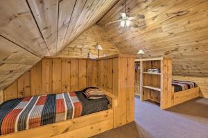 1 dormitorio con 1 cama en una cabaña de madera en Warm and Woodsy Rothbury Escape with Loft and Porch, en Rothbury