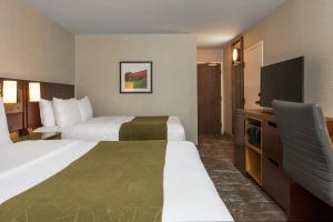 a hotel room with two beds and a flat screen tv at Comfort Inn Newmarket in Newmarket