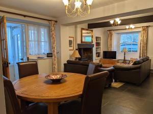 a living room with a table and a dining room at Rose Cottage in Ulverston