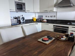a kitchen with a wooden table with a bowl of food on it at Panoramic sea views, sleeps 4, Torquay in Torquay