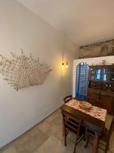 a dining room with a wooden table and a wall at Casa Corallo in Peschici +4 photos