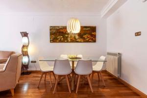 a dining room with a glass table and chairs at Apartamento Mariana Pineda Centro in Granada