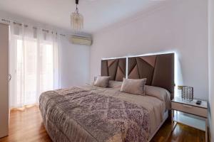a bedroom with a large bed with a large headboard at Apartamento Mariana Pineda Centro in Granada